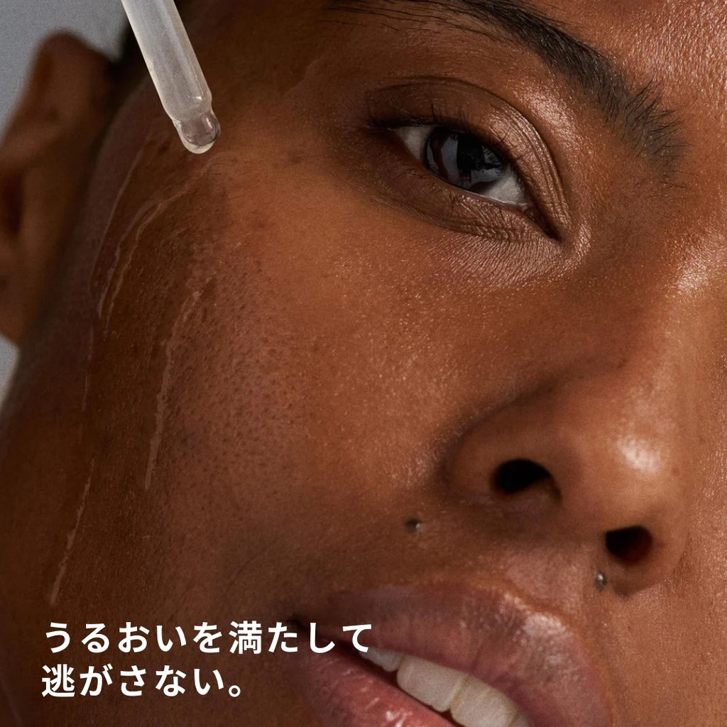 ダーマロジカ サーキュラーハイドレーションセラム — スポイトで美容液を顔に塗布するモデルの使用イメージ | 美容液・セラム