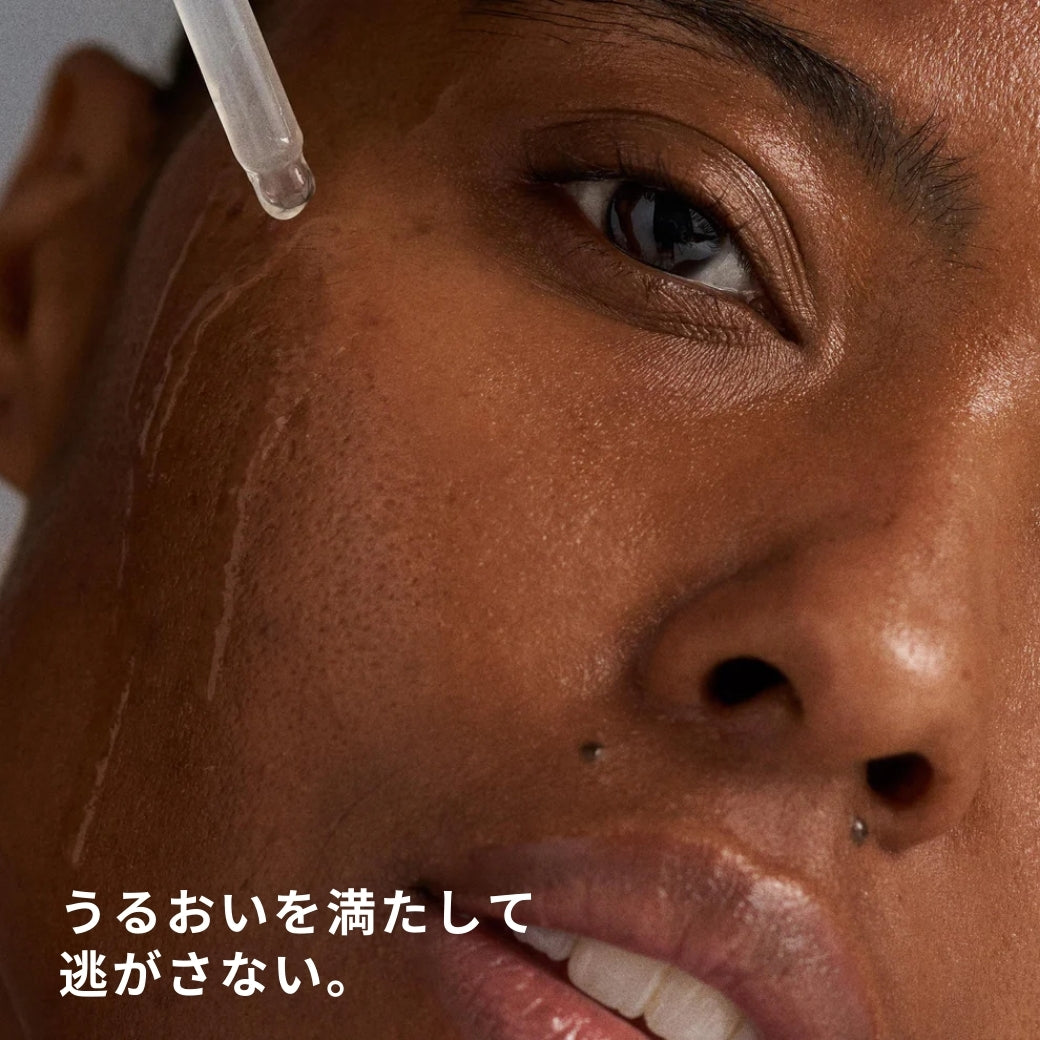 ダーマロジカ サーキュラーハイドレーションセラム — スポイトで美容液を顔に塗布するモデルの使用イメージ | 美容液・セラム