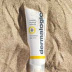 ダーマロジカ インビジブル フィジカル ディフェンス SPF30 — 砂浜に置かれた日焼け止めチューブの夏のビーチライフスタイルイメージ | 日焼け止め