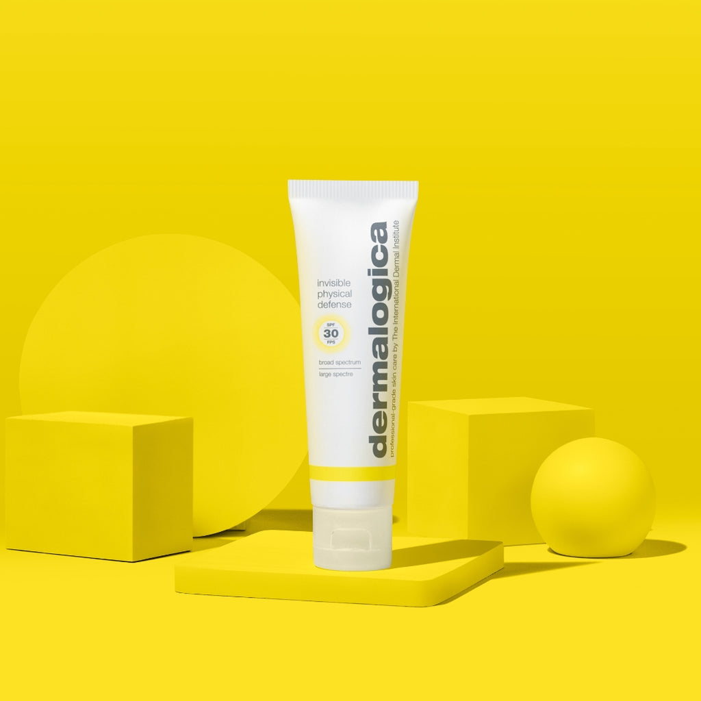 ダーマロジカ インビジブル フィジカル ディフェンス SPF30 — 黄色い幾何学オブジェクトとスタイリングされた日焼け止めチューブのビジュアル | 日焼け止め