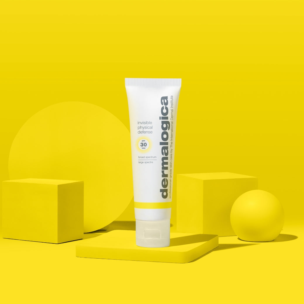 ダーマロジカ インビジブル フィジカル ディフェンス SPF30 — 黄色い幾何学オブジェクトとスタイリングされた日焼け止めチューブのビジュアル | 日焼け止め