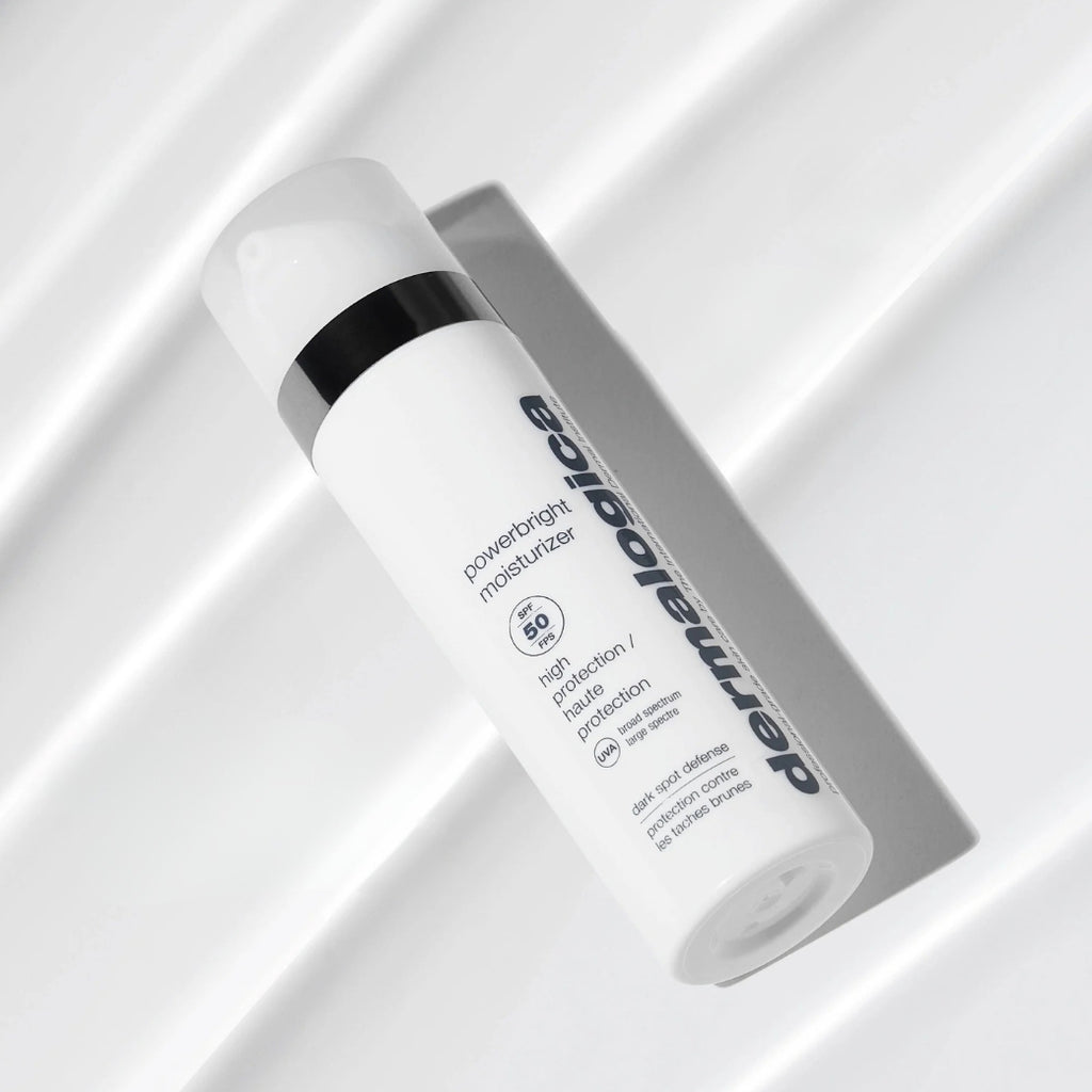 ダーマロジカ P-ブライト モイスチャライザー SPF50 — 白い布の上に斜めに置かれた製品ボトルのスタイリングショット | 日焼け止め・保湿クリーム