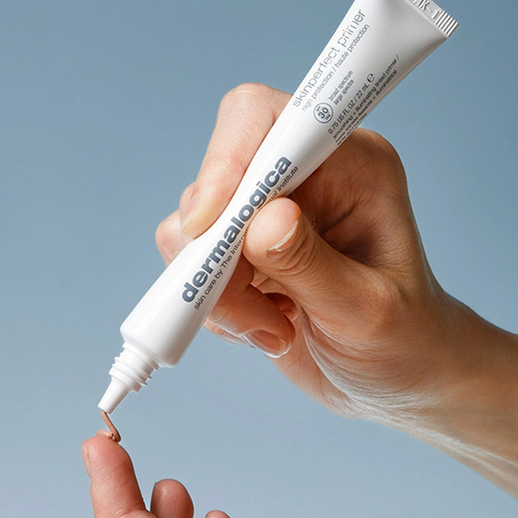 ダーマロジカ スキン パーフェクト プライマー SPF30 — チューブを手に持ち中身を出す使用イメージ | 化粧下地